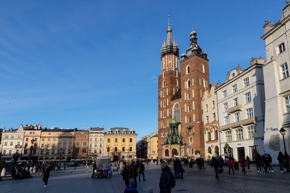 St Mary's Basilica and its two unequal towers on the Main Market Square in Krakow, Poland, with the townhouses of the square in low winter sun