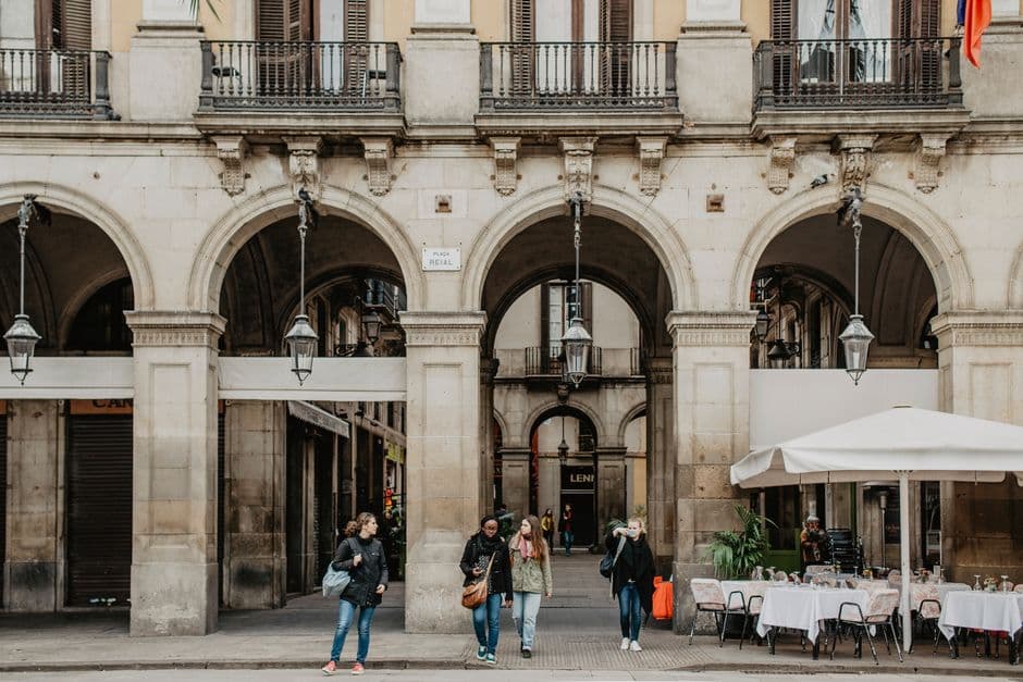 Restaurant terrace tables under the arcades of Placa Reial in Barcelona, one of the squares this guide tells you to walk past