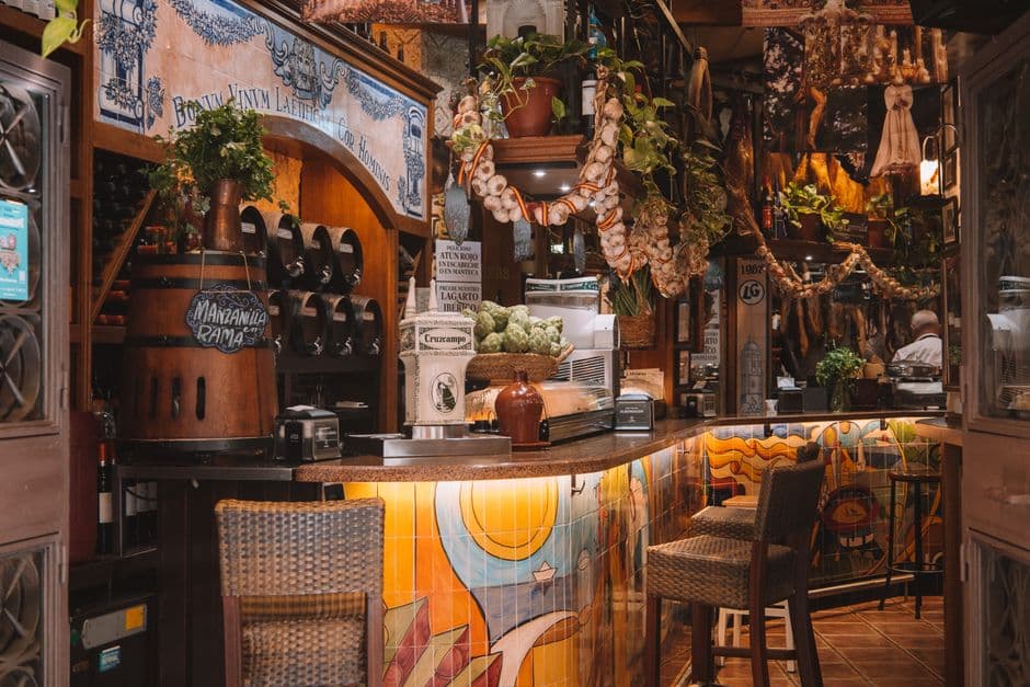 The tiled counter, barrel and hanging garlic of a traditional Spanish neighborhood bar, the format Poble-sec is built on