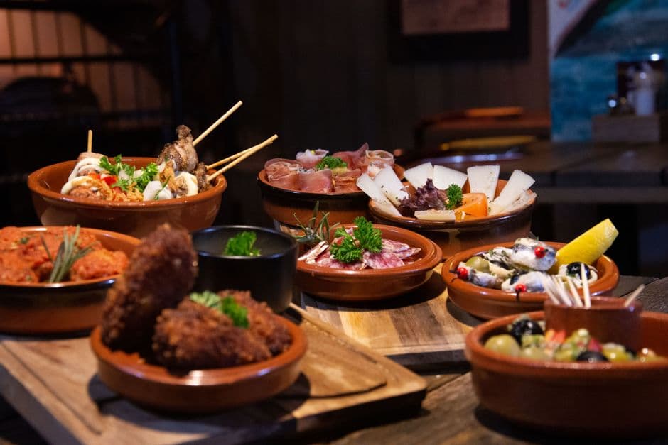 Small tapas plates on a bar counter in Barcelona, the standard way to eat in El Born and the Gothic Quarter