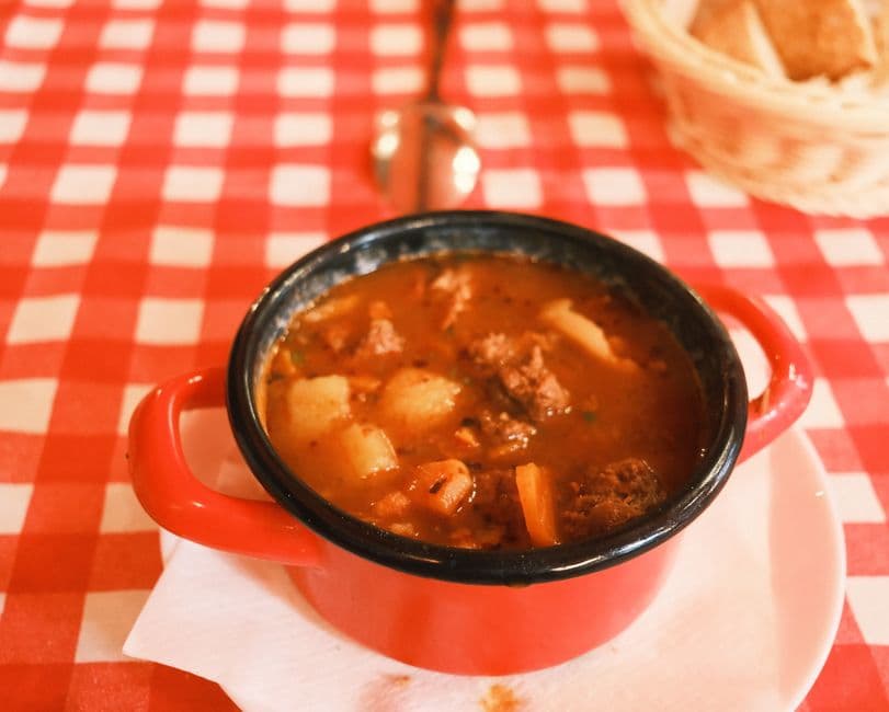 A bowl of Hungarian gulyas, the thin paprika beef soup that English speakers usually mistake for the thicker stew called porkolt