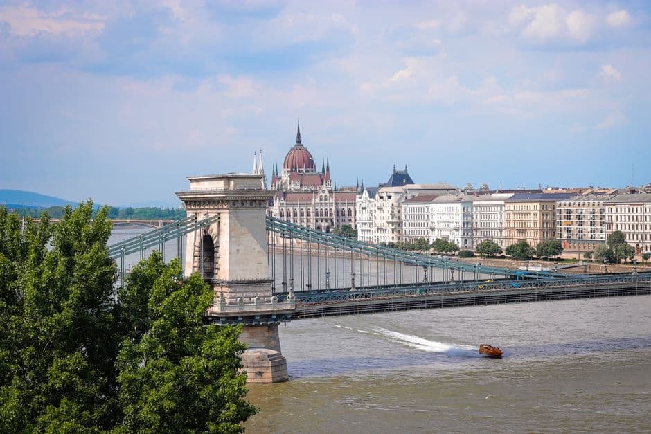 The Szechenyi Chain Bridge across the Danube in Budapest, with the Buda hills on the far bank and the flat Pest embankment in the foreground