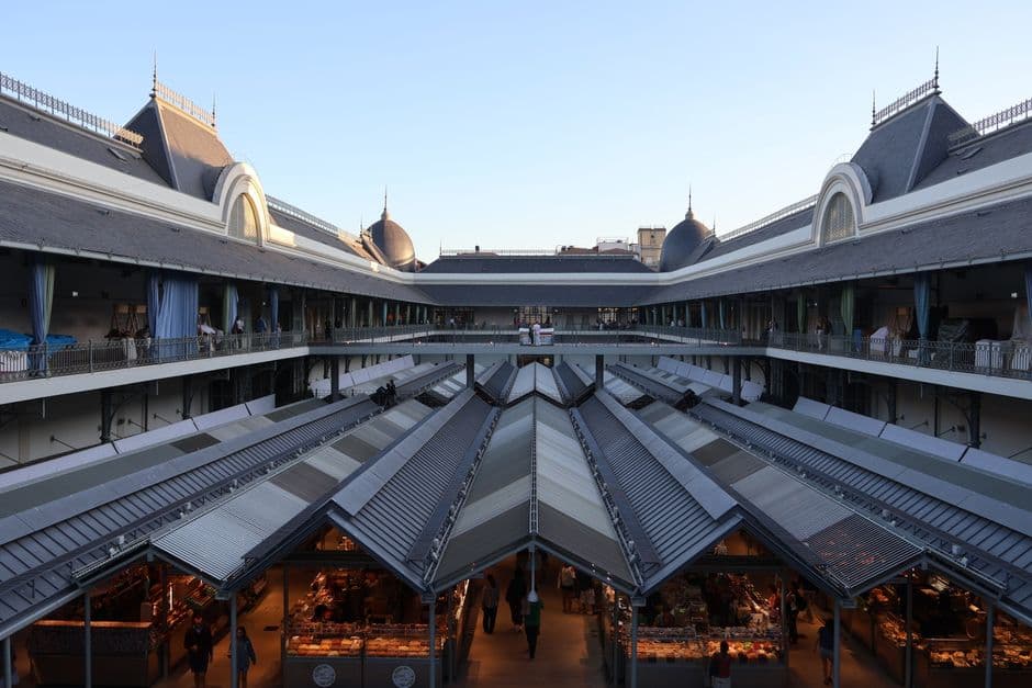 Paprika strings, salami and produce stalls under the iron roof of the Great Market Hall in Budapest's District IX