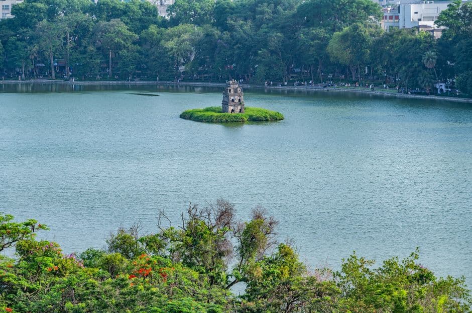 Hoan Kiem Lake in central Hanoi with the Turtle Tower on its small island, surrounded by green water and trees
