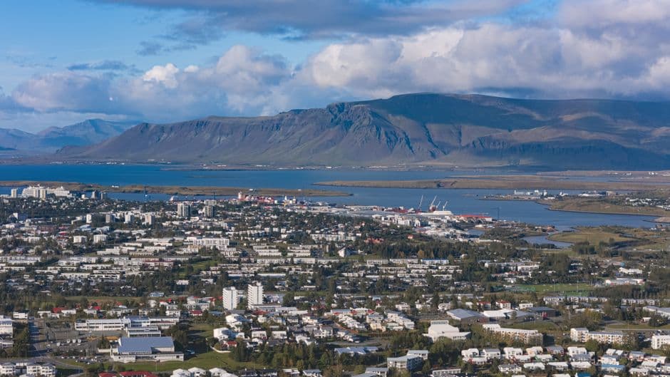 A high view over Reykjavik with the harbour and Faxafloi bay in the middle distance and the flat top of Mount Esja behind