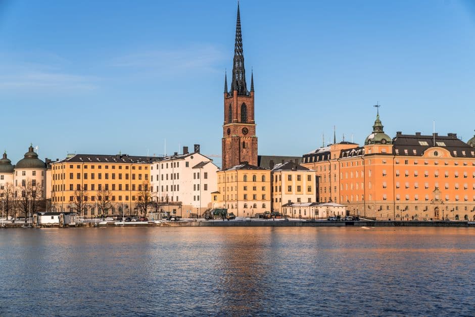 The Riddarholmen waterfront in central Stockholm seen across the water, with the cast iron spire of Riddarholmen Church above the rooftops