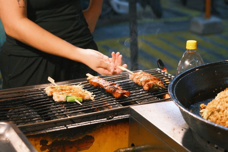 Grilled skewers cooking over charcoal at a street food stall