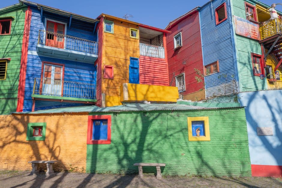 Brightly painted corrugated metal houses in blue, yellow, red and green on Caminito in La Boca, Buenos Aires