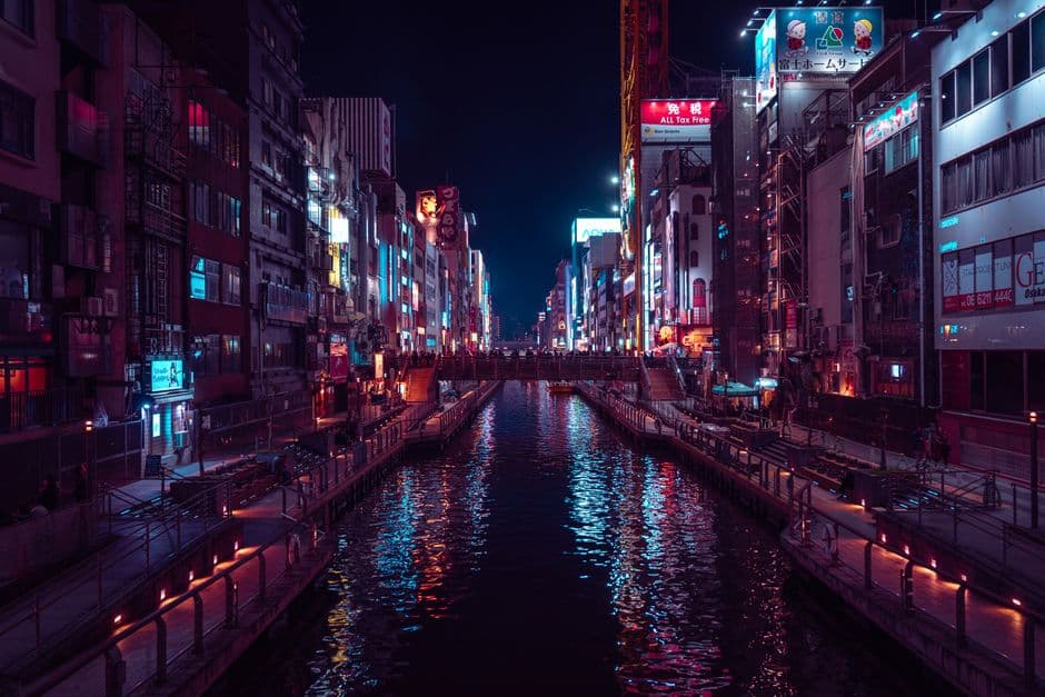 The Dotonbori canal in Osaka at night, neon signs reflected in the water between rows of buildings