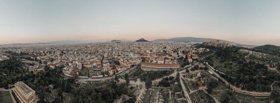 Aerial view of Athens at dusk, with the Ancient Agora and the Stoa of Attalos in the foreground, the Acropolis on the ridge to the right and Lycabettus Hill in the distance