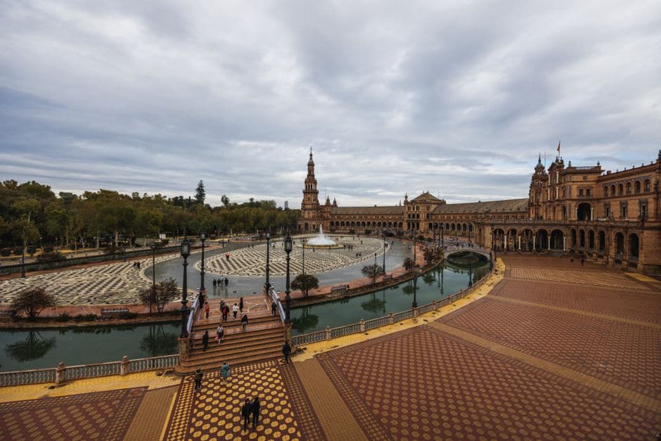The Plaza de Espana in Seville, its curved brick colonnade and tiled bridges seen across the canal