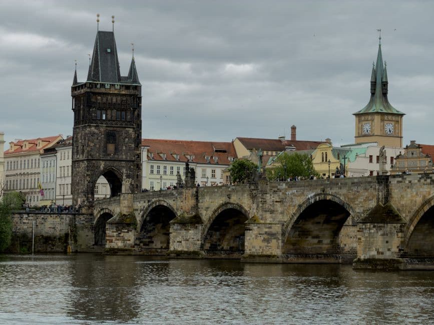 Charles Bridge in Prague seen from the river, with the Old Town Bridge Tower and the clock tower at Novotneho lavka behind it
